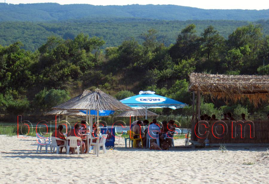 През лятото хората равномерно се разпределят между баровете на плажа и морето.